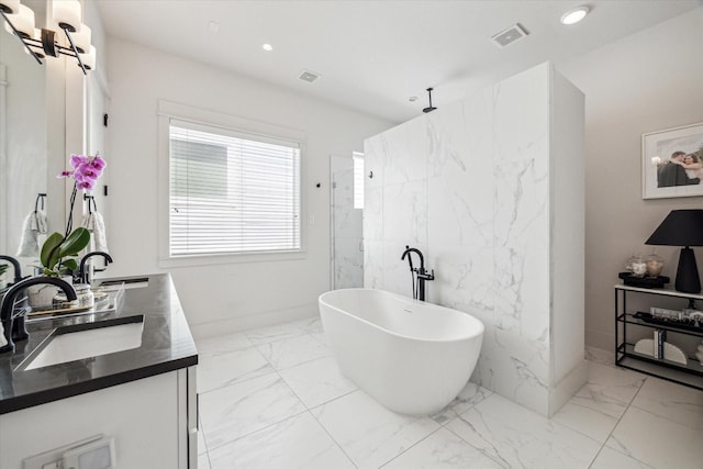 1026 Adele St, Houston, TX 77009 - bathroom featuring marble tiled flooring, double vanity, a freestanding tub, recessed lighting, and a marble finish shower