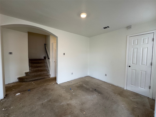 2606 Kiplands Ct, Houston, TX 77014 - spare room with concrete floors, arched walkways, and stairway