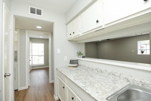 10601 S Dr Unit 73, Houston, TX 77099 - kitchen featuring white cabinets, wood finished floors, baseboards, and recessed lighting