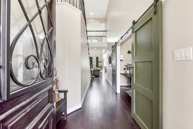 2610 Cedar Path Ln, Conroe, TX 77385 - entryway with a barn door, dark wood-style floors, baseboards, and a high ceiling