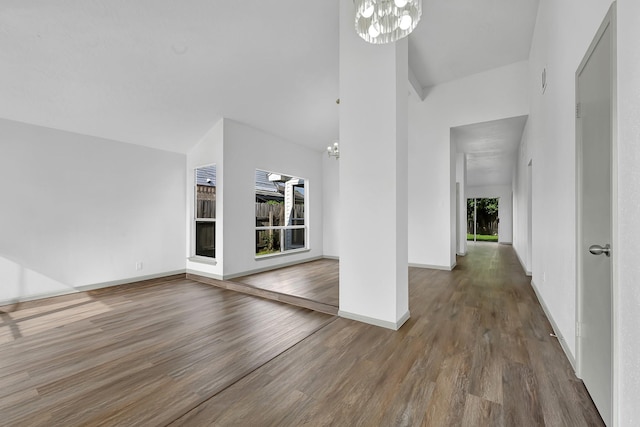 9911 Berry Limb Dr, Houston, TX 77099 - unfurnished living room with a chandelier, high vaulted ceiling, wood finished floors, and baseboards