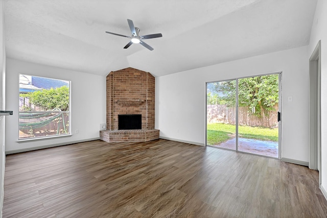 9911 Berry Limb Dr, Houston, TX 77099 - unfurnished living room with lofted ceiling, wood finished floors, a ceiling fan, a brick fireplace, and baseboards