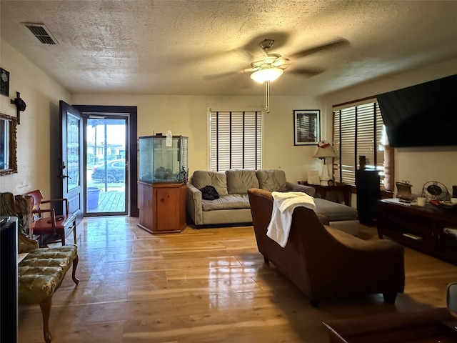1509 Harry St, Victoria, TX 77901 - living room featuring ceiling fan, light wood-type flooring, and a textured ceiling