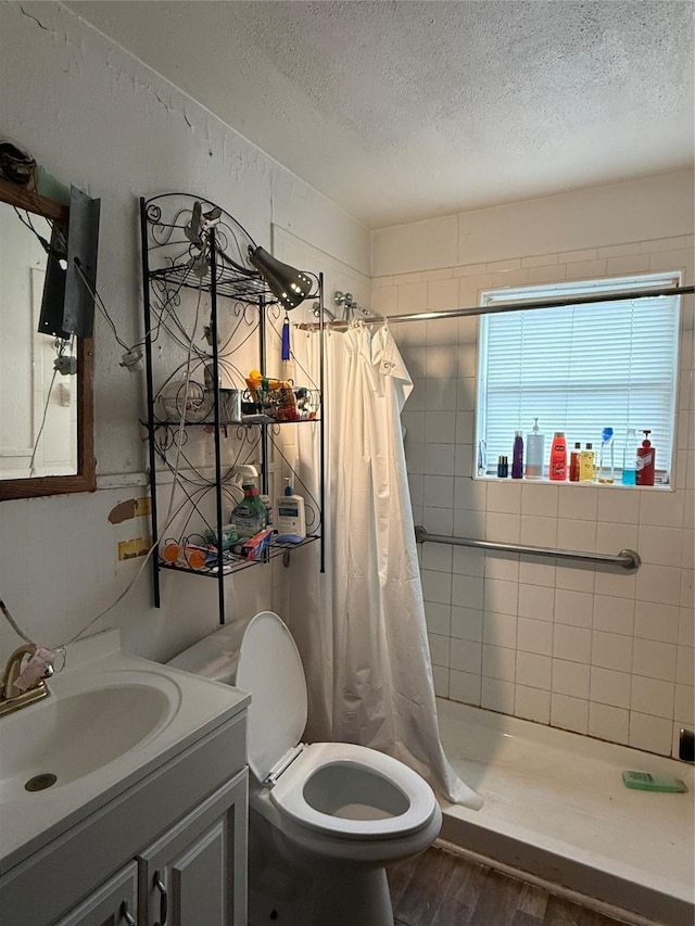 1509 Harry St, Victoria, TX 77901 - full bathroom with a textured ceiling, wood finished floors, vanity, a stall shower, and toilet