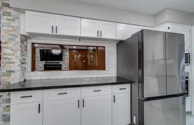 15014 Carol Chase Cir, Houston, TX 77489 - kitchen featuring freestanding refrigerator, dark stone countertops, and white cabinetry