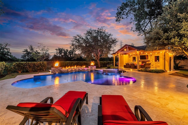 5306 Lockwood Bend Ln, Sugar Land, TX 77479 - pool at dusk with a fire pit, an exterior structure, a patio area, an in-ground hot tub, and an outbuilding