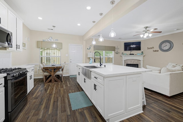 3518 Bain St, Houston, TX 77026 - kitchen featuring black gas stove, a sink, a fireplace, open floor plan, and recessed lighting