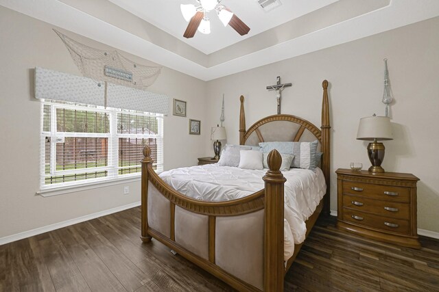 3518 Bain St, Houston, TX 77026 - bedroom featuring dark wood-style flooring, baseboards, a tray ceiling, and a ceiling fan