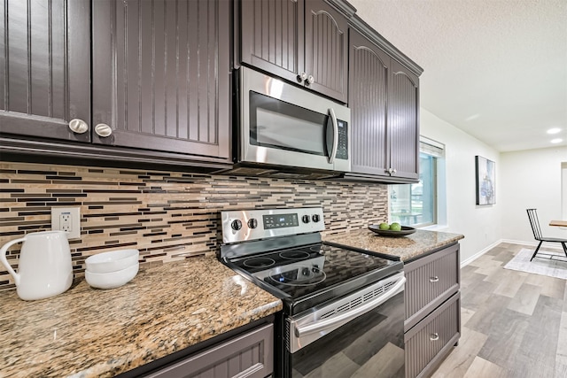 6315 Amie Ln Unit Cr879, Pearland, TX 77584 - kitchen with stainless steel appliances, decorative backsplash, light wood-style floors, light stone counters, and recessed lighting