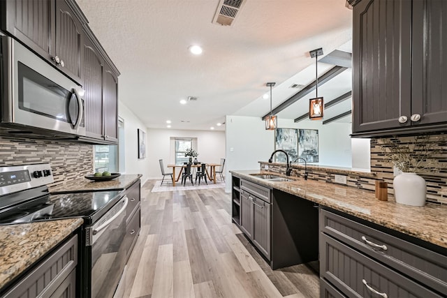 6315 Amie Ln Unit Cr879, Pearland, TX 77584 - kitchen with stainless steel appliances, a sink, tasteful backsplash, light wood finished floors, and light stone counters