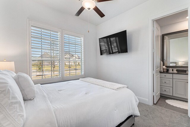 1059 Lakemont Bend Ln, Pinehurst, TX 77362 - carpeted bedroom with baseboards, a ceiling fan, and connected bathroom