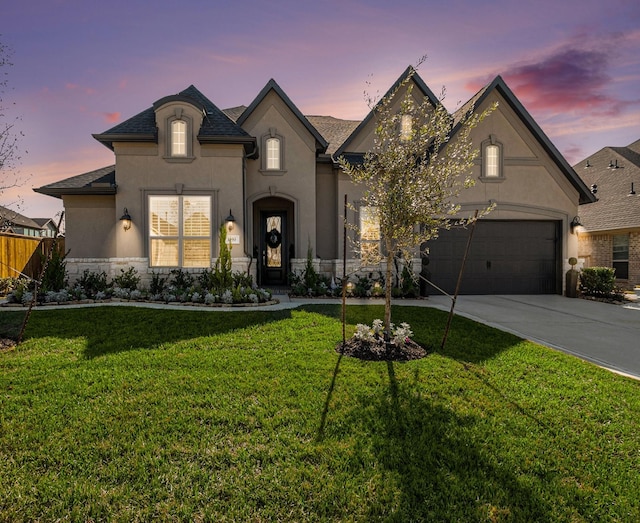 1059 Lakemont Bend Ln, Pinehurst, TX 77362 - french country style house with stucco siding, concrete driveway, roof with shingles, and an attached garage