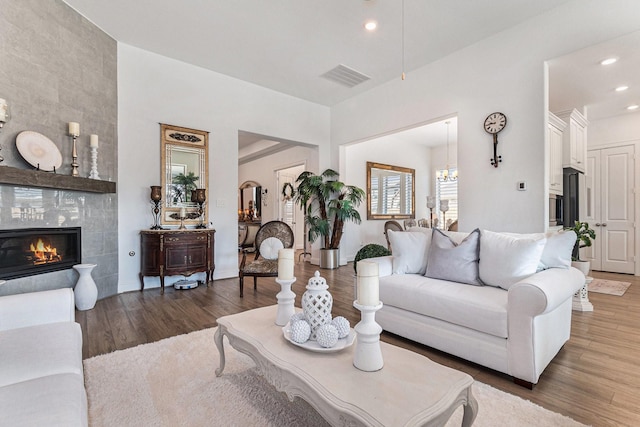1059 Lakemont Bend Ln, Pinehurst, TX 77362 - living area with wood finished floors, a tile fireplace, recessed lighting, and a chandelier
