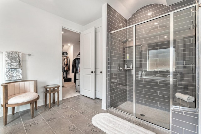 1059 Lakemont Bend Ln, Pinehurst, TX 77362 - bathroom with a stall shower, baseboards, vaulted ceiling, and a spacious closet