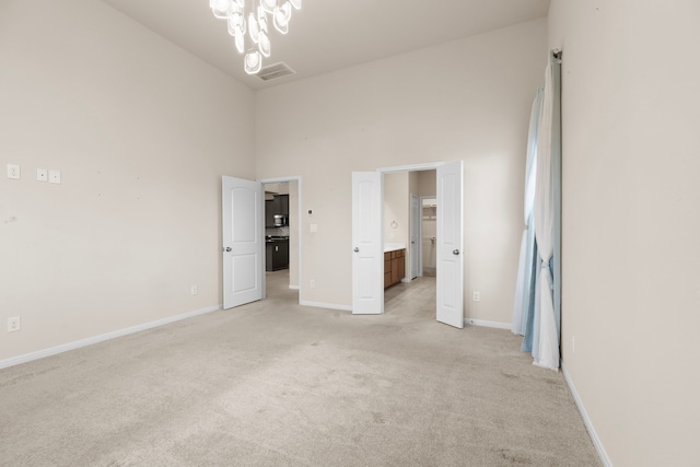 7603 Millstone Trail Ln, Richmond, TX 77469 - unfurnished bedroom featuring light colored carpet, baseboards, a chandelier, a high ceiling, and connected bathroom