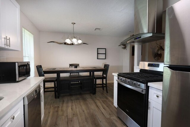 13911 W Richmond St, Needville, TX 77461 - kitchen featuring stainless steel appliances, wall chimney range hood, a chandelier, and white cabinetry