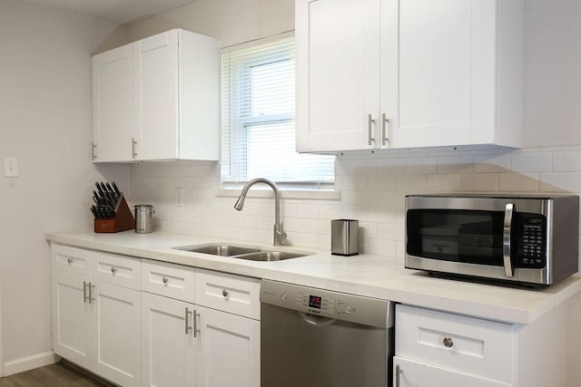 13911 W Richmond St, Needville, TX 77461 - kitchen featuring appliances with stainless steel finishes, a sink, backsplash, and white cabinetry