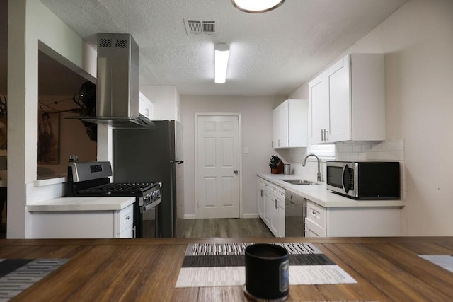13911 W Richmond St, Needville, TX 77461 - kitchen with stainless steel appliances, a sink, white cabinetry, dark wood finished floors, and a textured ceiling