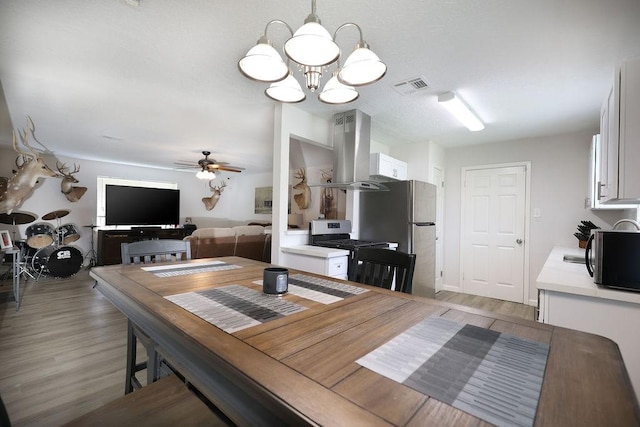 13911 W Richmond St, Needville, TX 77461 - dining space with a chandelier, light wood finished floors, and ceiling fan