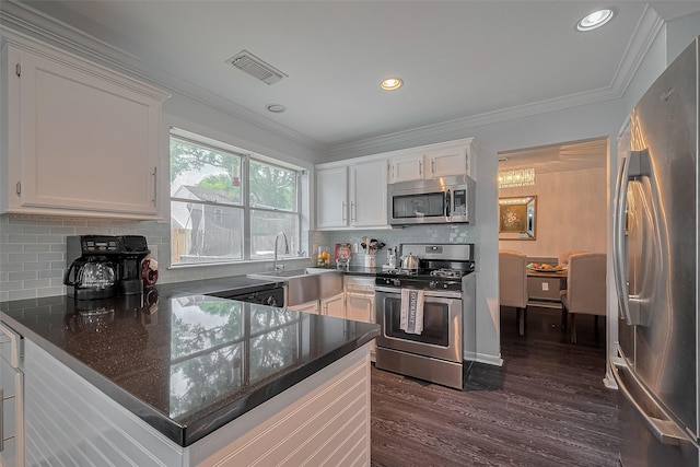 18206 Lake Bend Dr, Houston, TX 77084 - kitchen with stainless steel appliances, white cabinets, a peninsula, dark wood-style flooring, and tasteful backsplash