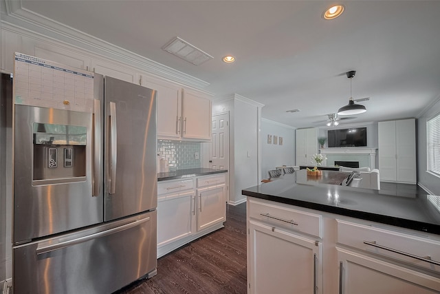 18206 Lake Bend Dr, Houston, TX 77084 - kitchen with stainless steel fridge, ornamental molding, a fireplace, dark wood-style flooring, and dark countertops