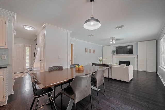18206 Lake Bend Dr, Houston, TX 77084 - dining room featuring dark wood-style flooring, ornamental molding, a fireplace, and a ceiling fan