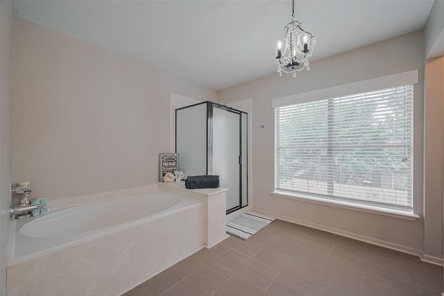 18206 Lake Bend Dr, Houston, TX 77084 - full bath featuring a bath, a shower stall, a chandelier, and baseboards