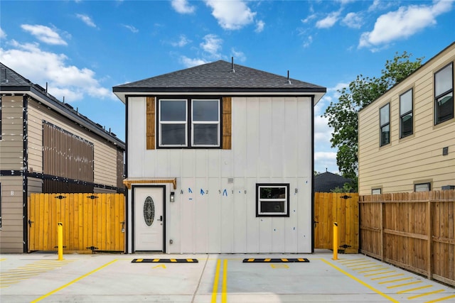 2310 Wavell St, Houston, TX 77088 - back of property featuring roof with shingles, a gate, uncovered parking, and board and batten siding