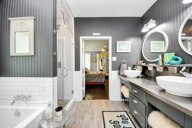8910 Burleson Ct, Houston, TX 77064 - ensuite bathroom with a stall shower, wood finished floors, a garden tub, double vanity, and tile walls