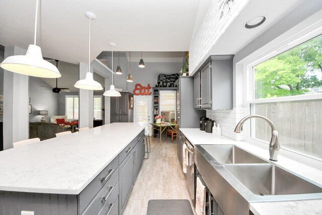 8910 Burleson Ct, Houston, TX 77064 - kitchen with gray cabinets, a sink, a spacious island, light wood finished floors, and dishwasher