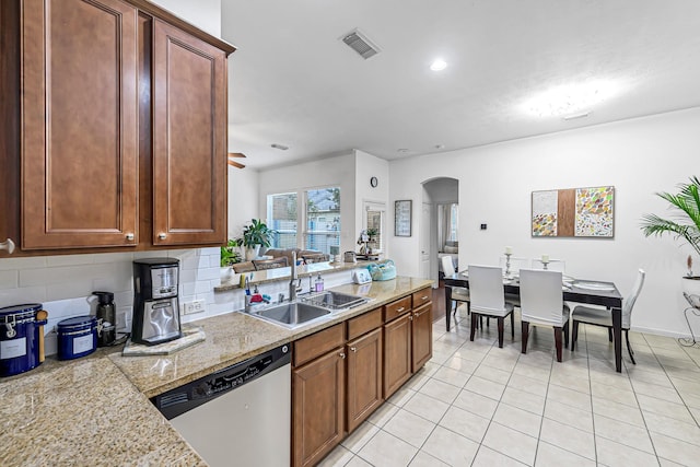5306 Brookway Dr, Houston, TX 77084 - kitchen featuring dishwasher, a sink, arched walkways, decorative backsplash, and light tile patterned floors