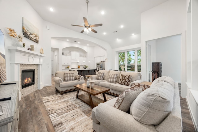 23603 Bottlebrush Terrace Trl, Katy, TX 77493 - living room with ceiling fan, arched walkways, vaulted ceiling, wood finished floors, and a glass covered fireplace