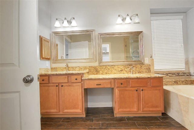 3014 Brahman Dr, Manvel, TX 77578 - bathroom with double vanity, a garden tub, and wood tiled floors