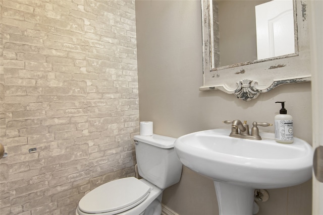 3014 Brahman Dr, Manvel, TX 77578 - bathroom featuring toilet, brick wall, and a sink