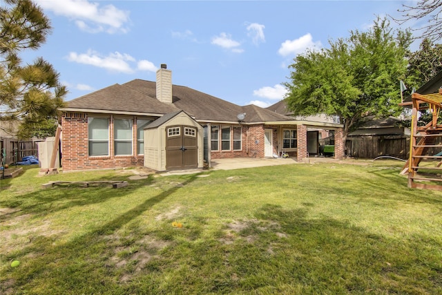 3014 Brahman Dr, Manvel, TX 77578 - rear view of house featuring a patio area, a chimney, brick siding, a shingled roof, and a playground