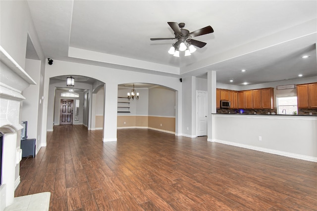 3014 Brahman Dr, Manvel, TX 77578 - unfurnished living room featuring a ceiling fan, dark wood-type flooring, arched walkways, recessed lighting, and baseboards