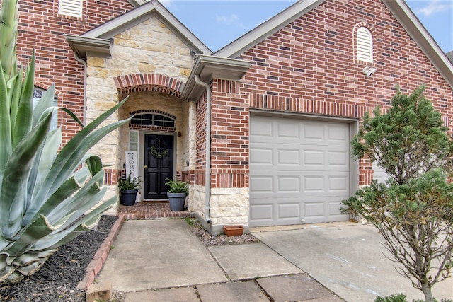 3014 Brahman Dr, Manvel, TX 77578 - property entrance featuring stone siding, an attached garage, brick siding, and driveway