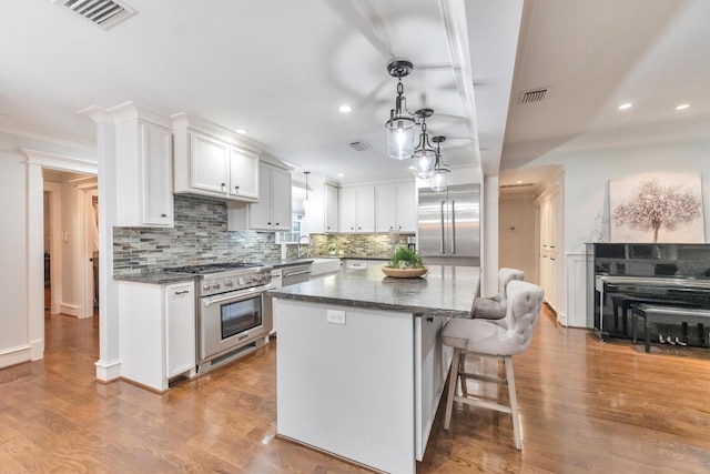 970 W 41st St, Houston, TX 77018 - kitchen featuring high quality appliances, ornamental molding, recessed lighting, backsplash, and a center island
