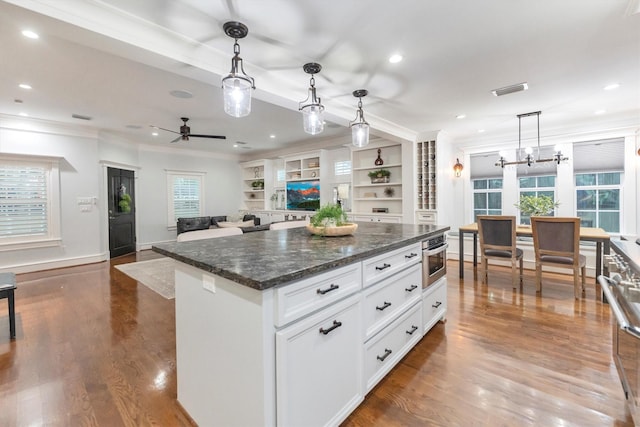 970 W 41st St, Houston, TX 77018 - kitchen featuring ornamental molding, dark wood-style floors, white cabinets, recessed lighting, and a kitchen island