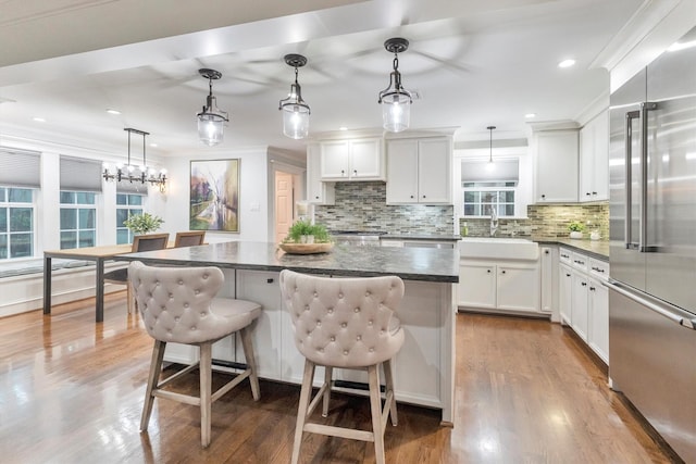 970 W 41st St, Houston, TX 77018 - kitchen with high end refrigerator, a sink, backsplash, wood finished floors, and a kitchen island
