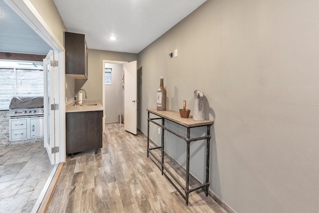 970 W 41st St, Houston, TX 77018 - kitchen with a sink, light countertops, light wood-style flooring, and baseboards
