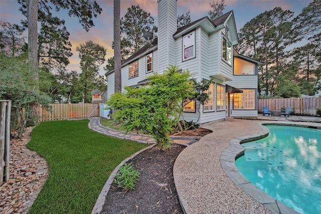 18 Heather Wisp Ct, Spring, TX 77381 - back of property at dusk featuring a chimney, a gate, and a patio