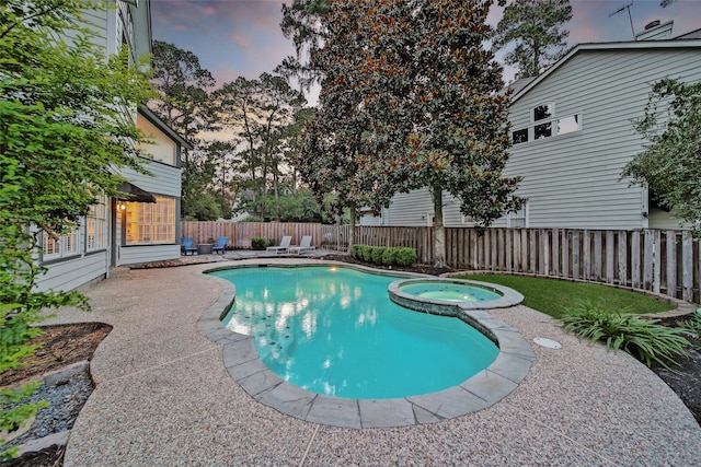 18 Heather Wisp Ct, Spring, TX 77381 - pool at dusk with a fenced backyard, a pool with connected hot tub, and a patio