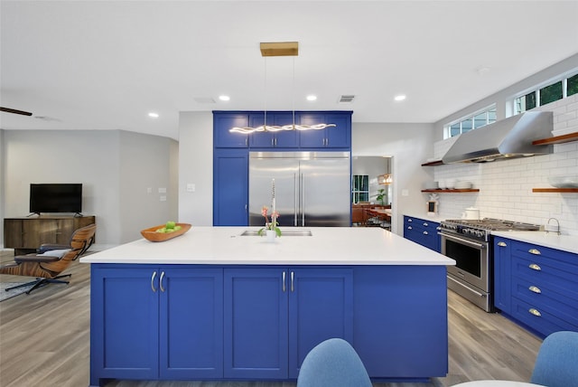 18 Heather Wisp Ct, Spring, TX 77381 - kitchen featuring appliances with stainless steel finishes, open shelves, blue cabinetry, light wood-style floors, and recessed lighting