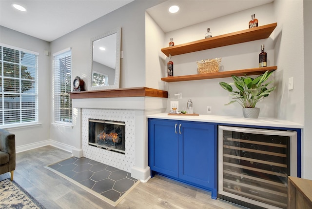 18 Heather Wisp Ct, Spring, TX 77381 - indoor dry bar featuring beverage cooler, light wood-type flooring, a glass covered fireplace, recessed lighting, and baseboards