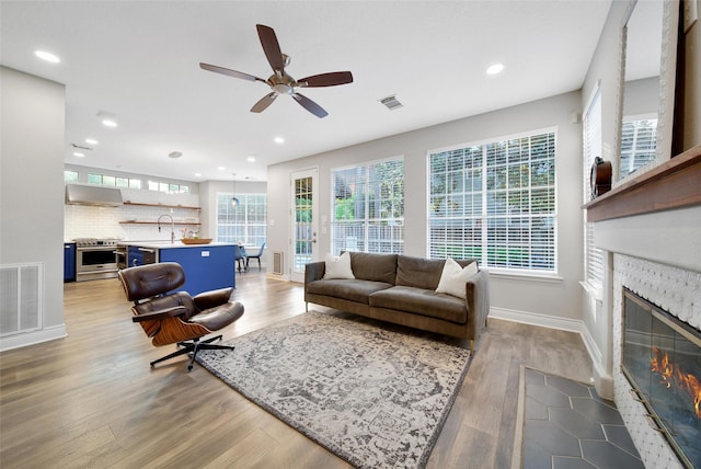 18 Heather Wisp Ct, Spring, TX 77381 - living room featuring plenty of natural light, baseboards, light wood-style floors, a fireplace with flush hearth, and recessed lighting