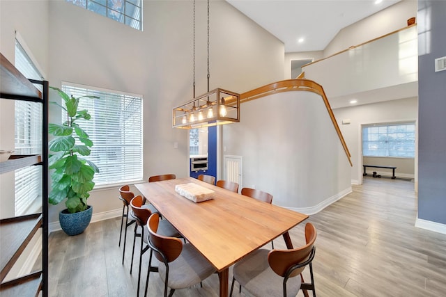 18 Heather Wisp Ct, Spring, TX 77381 - dining space with a towering ceiling, light wood-type flooring, baseboards, stairway, and a chandelier