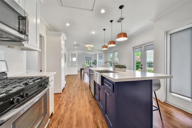 724 E 21st St, Houston, TX 77008 - kitchen with stainless steel appliances, a sink, a breakfast bar area, light countertops, and light wood-type flooring