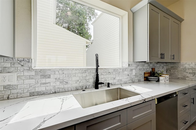 2905 Nagle St, Houston, TX 77004 - kitchen with stainless steel dishwasher, a sink, gray cabinetry, and backsplash
