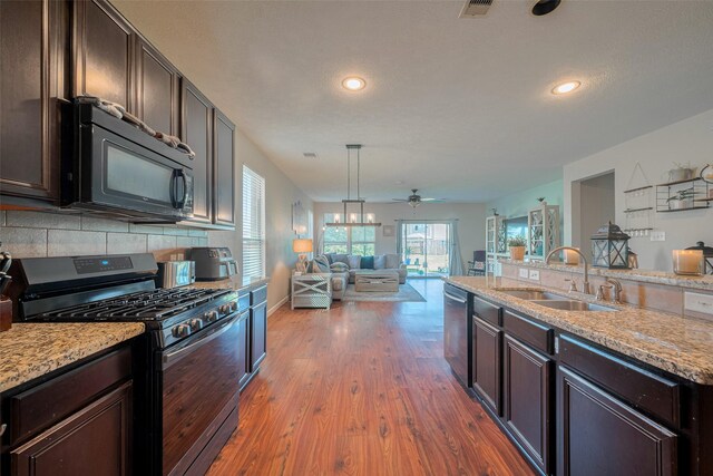 4323 N Vineyard Mdw Ln, Katy, TX 77449 - kitchen with appliances with stainless steel finishes, a sink, open floor plan, dark brown cabinetry, and recessed lighting